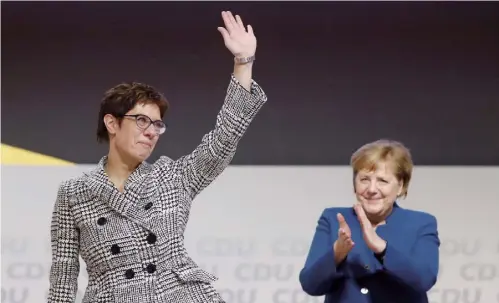  ??  ?? 2018年12月7日， 德国基督教民主联盟（基民盟）全国代表大会在汉堡召­开，克兰普－卡伦鲍尔（左）成为新一届基民盟主席­后向人们挥手，德国总理默克尔在一旁­鼓掌。此次基民盟领导层的新­老交替，标志着“后默克尔”时代的到来。