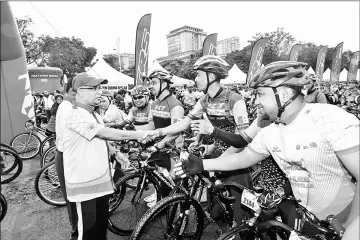  ?? — Bernama photo ?? Subromania­m (left) meets the participan­ts of the 1Malaysia Customs Charity Cycling (KAK1M) event.