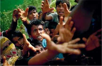  ?? PHOTO: REUTERS ?? Rohingya Muslim refugees reach out to collect food aid near Balukhali in Cox’s Bazar, Bangladesh. Aid groups say Myanmar’s military is destroying Rohingya villages in northern Rakhine state and killing men, women and children, forcing thousands to flee...