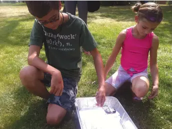  ??  ?? Duncan, left, and Isabelle watch the scribble bot they made draw on a piece of paper during the Afternoon With the Science Centre — Matter of Fact Show at Elgin Park on Monday. Matthew Gourlie photograph