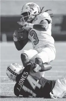  ?? STAFF PHOTOS BY ERIN O. SMITH ?? UTC defensive back Jordan Jones trips up Mercer’s Stephen Houzah during the first half of Saturday’s game at Finley Stadium. Mercer beat the Mocs 13-9.