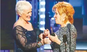  ??  ?? BETTE MIDDLER (right) receives her Best Actress trophy from her “The Stepford Wives” co-star Glenn Close.