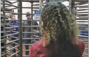  ?? (AP/South Florida Sun-Sentinel/Amy Beth Bennett) ?? Postal workers talk with U.S. Rep. Debbie Wasserman Schultz, D-Fla., through metal turnstiles Friday at the blocked entrance to the Miami Processing and Distributi­on Center in Miami.