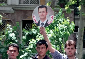  ??  ?? Des étudiants syriens installés à Téhéran montrent leur soutien à Bachar al-assad, en mai 2013.