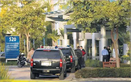  ?? Mark Boster Los Angeles Times ?? EMPLOYEES at a medical clinic in Newport Beach speak with authoritie­s after Dr. Ronald Gilbert was slain in a nearby building in 2013.