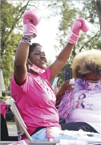  ?? Katie West • Times-Herald ?? Breast cancer and domestic violence surviver Eugenia Edwards holds up a set of boxing gloves during the Pink Rubies Breast Cancer and Domestic Violence March on Saturday. Participan­ts marched or rode from Forrest City City Hall to the Forrest City Civic Center. More pictures from the march can be found on Page 8 of today’s Times-Herald.