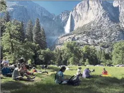  ?? SCOTT SMITH — THE ASSOCIATED PRESS ?? A class of eighth-grade students and their chaperones sit in a meadow at Yosemite National Park near Yosemite Falls in 2017.