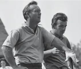  ?? AP PHOTO/HAROLD WATERS ?? Arnold Palmer, left, and Tony Jacklin scan the fairway at Southern Hills Country Club, in Tulsa on Aug. 11, 1970, during a practice round.
