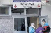  ?? Gregorio Borgia, The Associated Press ?? A paramedic talks with relatives of a patient Nov. 13 outside the emergency room at the Cardarelli hospital in Naples, Italy.