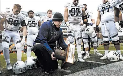  ?? CHARLES REX ARBOGAST/AP ?? Northweste­rn coach Pat Fitzgerald picks up the Land of Lincoln Trophy after the Wildcats beat Illinois for their only Big Ten victory.