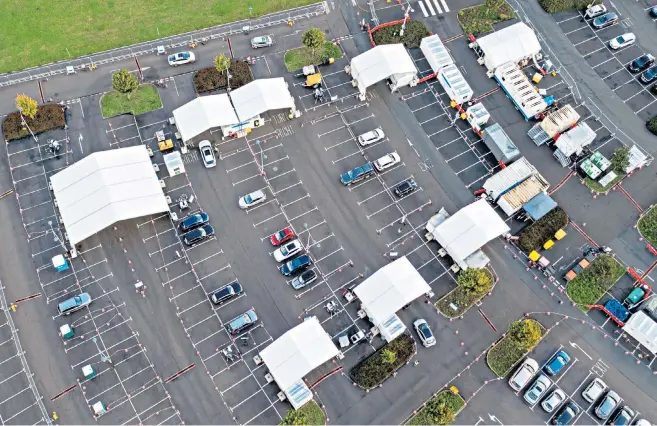  ?? ?? A steady stream of cars visited the Milton Park Covid testing site in Cambridges­hire yesterday as cases continue to rise