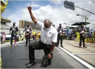  ?? Brynn Anderson/Associated Press ?? ■ A NASCAR official kneels during the national anthem before a NASCAR Cup Series race Sunday at Atlanta Motor Speedway in Hampton, Ga.