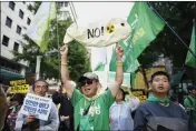  ?? LEE JIN-MAN — THE ASSOCIATED PRESS ?? People hold banners and posters to protest Japan's plan to release treated radioactiv­e water from the wrecked Fukushima nuclear power plant during a match along a street in Seoul, South Korea, Saturday.