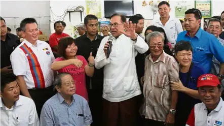  ??  ?? Rallying support: Anwar (centre) addressing the crowd during a campaign talk at a coffee shop in Lukut. With him are (seated from left) Lukut assemblyma­n Choo Ken Hwa, DAP adviser Lim Kit Siang and Sungai Pelek assemblyma­n Ronnie Liu.