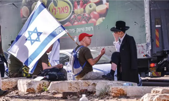  ?? © Matan C-Golan/getty ?? Een demonstran­t en een orthodoxe man tijdens een protest tegen de uitzonderi­ngen op de legerdiens­t voor ultraortho­doxe joden.