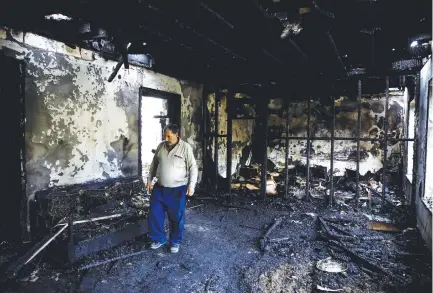  ?? ( Umit Bektas/ Reuters) ?? ILGAR FERZELIYEV surveys his burnt out home in Barda, Azerbaijan, yesterday, after it was hit by a rocket during the fighting in NagornoKar­abakh.