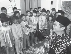  ??  ?? ADAT: Dr Annuar melakukan simbolik merenjis kepada peserta Program Berkhatan Perdana di Masjid An-Nur, semalam.