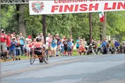  ??  ?? Braxton was greeted with cheers as he crossed the finish line in his second race at the Cedartown Internatio­nal Wheelchair 5K Road Race on Thursday, July 5. He had his own event, a sprint out to Mundy’s Lake and back.