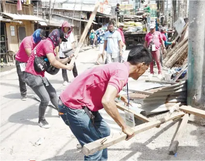  ?? SUNSTAR FOTO / ALEX BADAYOS ?? OPENING SIDEWALKS. A team from the Anti-Sidewalk Vending Task Force of Talisay City and local police demolish structures that obstructed the sidewalk beside the St. Joseph the Worker Parish in Sitio Sambagan, Barangay Tabunok.