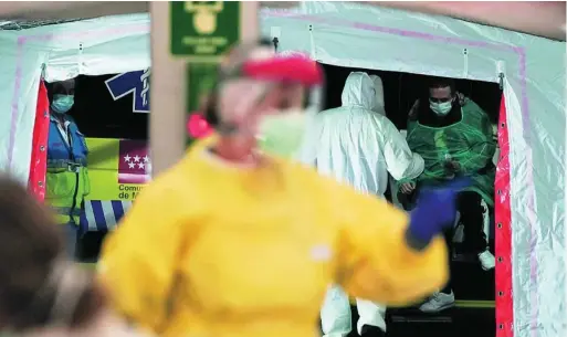  ?? REUTERS ?? Pacientes y personal sanitario a las puertas del hospital instalado en Ifema, Madrid