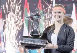  ?? — AFP ?? Elina Svitolina of Ukraine celebrates with the trophy after winning the final of the Dubai Tennis Championsh­ips.