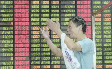  ??  ?? An investor reacts in front of an electronic screen showing stock informatio­n at a brokerage house in Shanghai.