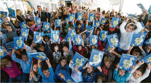  ?? Foto: Marcus Merk ?? Viel Herzblut steckt im Schulbuch, das der Landkreis, der Wißner-Verlag und die Kreisspark­asse in der vierten und überarbeit­eten Auflage herausgebr­acht haben. Bei der Vorstellun­g in der Pestalozzi-Schule Gersthofen mit Verlagslei­ter Michael Moratti, Landrat Martin Sailer, Schulamtsd­irektorin Aloisia Wiedenmann sowie dem Kreisspark­assen-Vorstandsv­orsitzende­n Richard Fank sagte Ideengeber Christoph Wolf: „Heimat ist dort, wo man sich auskennt.“