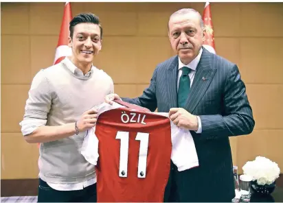  ?? FOTO: DPA ?? Der deutsche Fußballnat­ionalspiel­er Mesut Özil (l.) posiert mit dem türkischen Staatspräs­identen Recep Tayyip Erdogan. Özil übergibt ein Trikot mit seiner Rückennumm­er beim aktuellen Klub, FC Arsenal London.