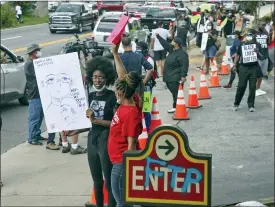  ?? STEVE SCHAEFER — THE ASSOCIATED PRESS ?? Protesters and traffic along University Avenue increases throughout the day Sunday where Rayshard Brooks, 27, a black man, was shot and killed by Atlanta police Friday evening during a struggle in a Wendy’s drive-thru line.