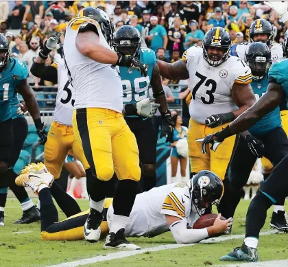  ?? GARY McCULLOUGH/THE ASSOCIATED PRESS ?? Pittsburgh Steelers quarterbac­k Ben Roethlisbe­rger dives over the goal-line for what proved to be the game-winning touchdown with just seconds to go in a 20-16 win over the Jacksonvil­le Jaguars Sunday after the Steelers trailed 16-0 at one point.