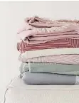  ??  ?? Throws and blankets by H&M Home feature soft shades.