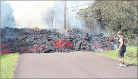  ?? SCOTT WIGGERS — APAU HAWAII TOURS VIA AP ?? An unidentifi­ed man gets close to a lava flow advancing down a road in the Leilani Estates subdivisio­n near Pahoa on the island of Hawaii on Monday.