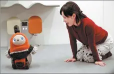 ?? KIM KYUNG-HOON / REUTERS ?? A woman calls up GROOVE X’s new home robot LOVOTTM at its demonstrat­ion during the launch event in Tokyo on Dec 18.