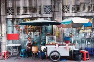  ??  ?? BANGKOK: A Thai street food vendor waits for customers at China town in Bangkok. —AP
