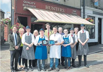 ?? Picture: Perthshire Picture Agency. ?? Lord Duncan, back centre, with Pamela and Ian Hunter, Lisa Macinnes from Save A Life For Scotland, MP Luke Graham, Douglas Scott, chief executive of Scottish Craft Butchers, and the staff at Hunters of Kinross with the defibrilla­tor.