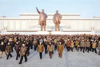  ?? — AFP ?? People leave after paying their respects before the statues of late North Korean leaders Kim Il Sung and Kim Jong Il as part of celebratio­ns marking the birthday of late North Korean leader Kim Jong Il, known as the ‘Day of the Shining Star’, on Mansu hill in Pyongyang on Saturday.