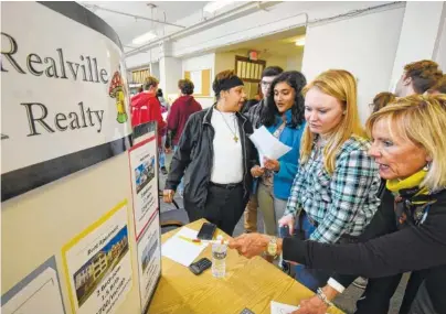  ?? STAFF PHOTO BY TIM BARBER ?? Beth Harrell, right, helps senior Chattanoog­a School for the Arts and Sciences student Regina Vaughn with budgeting living expenses during Wednesday’s Reality Check workshop. Robin Smith, left, and Parneeta Mohapatra deal with the same issues.