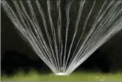  ?? RICH PEDRONCELL­I — THE ASSOCIATED PRESS FILE ?? Water flies from a sprinkler on a lawn in Sacramento on July 8, 2021.