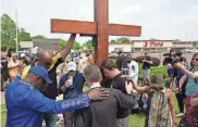  ?? JOSHUA BESSEX/AP FILE ?? People pray for the victims of the Buffalo, N.Y., supermarke­t shooting last May. A report says all extremist killings identified in 2022 were linked to right-wing extremism.