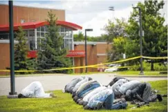  ?? THE ASSOCIATED PRESS ?? Mohamed Omar, left, the executive director of the Dar Al Farooq Center Islamic Center leads afternoon prayers outside the police tape surroundin­g the center in Bloomingto­n, Minn.