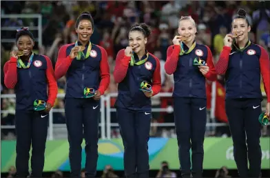  ??  ?? Final Five: U.S. gymnasts, left to right, Simone Biles, Gabrielle Douglas, Lauren Hernandez, Madison Kocian and Aly Raisman hold their gold medals during the medal ceremony for the artistic gymnastics women's team at the 2016 Summer Olympics in Rio de...