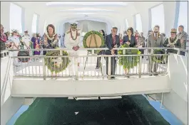  ?? [DENNIS ODA/(HONOLULU)STAR-ADVERTISER] ?? Pacific Fleet Commander Adm. Scott Swift, left center, and Hawaii Gov. David Ige, right center, join their wives and others in tossing orchids into the water at the USS Arizona Memorial during Thursday’s ceremony.