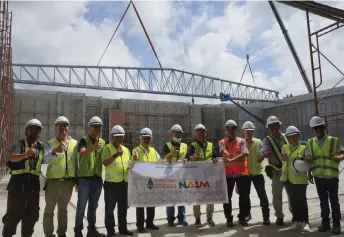  ?? ?? Abdul Hamed (fifth left) and Hasmi (sixth right) give the thumbs up as they pose for a group photo during the installati­on of the steel roof trusses for Wisma Melayu Sarawak.