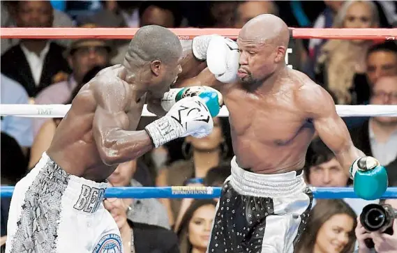  ??  ?? Floyd Mayweather Jr. -a la derecha- recibe una izquierda de parte de Andre Berto durante el combate del sábado. El norteameri­cano se alzó con un cómodo triunfo por decisión.