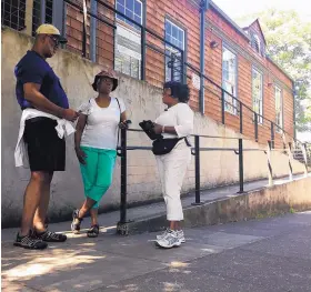  ?? GILLIAN FLACCUS/ASSOCIATED PRESS ?? From left, Ron Young, Gahlena Easterly and Sharon Steen reminisce as they take a mile-long walk through what was once the center of Portland, Ore.’s African-American community. Researcher­s are studying whether jogging memories where they were made can...