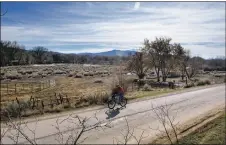  ?? TAOS NEWS FILE PHOTO ?? A man rides his bike down Quesnel Street in front of Couse Pasture in 2016. Town councilor George ‘Fritz’ Hahn in a Tuesday (Sept. 22) meeting called for a cleanup effort at the property that he says is full of vagrants, used syringes, trash and trouble.