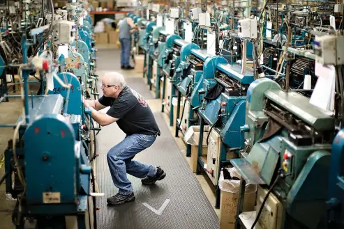  ?? AP Photo/ Matt Rourke ?? above Jeff Geletka operates a knitting machine used in the manufactur­ing of Kangol hats May 1 at the Bollman Hat Co. in Adamstown, Pa. When the famous hat brand worn by celebritie­s like Samuel L. Jackson, Brad Pitt and Gwen Stefani moved into the...