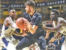  ?? STAFF PHOTO BY ROBIN RUDD ?? UTC’s Ramon Vila, center, looks to pass while pressured by UNC Greensboro’s James Dickey, left, and Eric Hamilton during Saturday night’s game at McKenzie Arena. UNCG won 78-63.