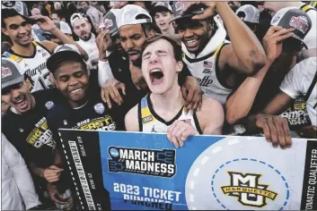  ?? JOHN MINCHILLO/AP ?? MARQUETTE’S TYLER KOLEK, TOURNAMENT MVP (CENTER) celebrates with his teammates after winning their game against Xavier for the championsh­ip of the Big East men’s tournament on Saturday in New York.