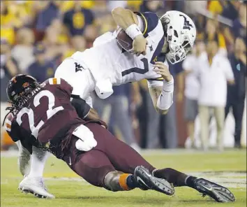  ?? Patrick Semansky/Associated Press ?? Virginia Tech safety Terrell Edmunds tackles West Virginia quarterbac­k Will Grier last season. Steelers coach Mike Tomlin said Edmunds “checks all the boxes for us.”